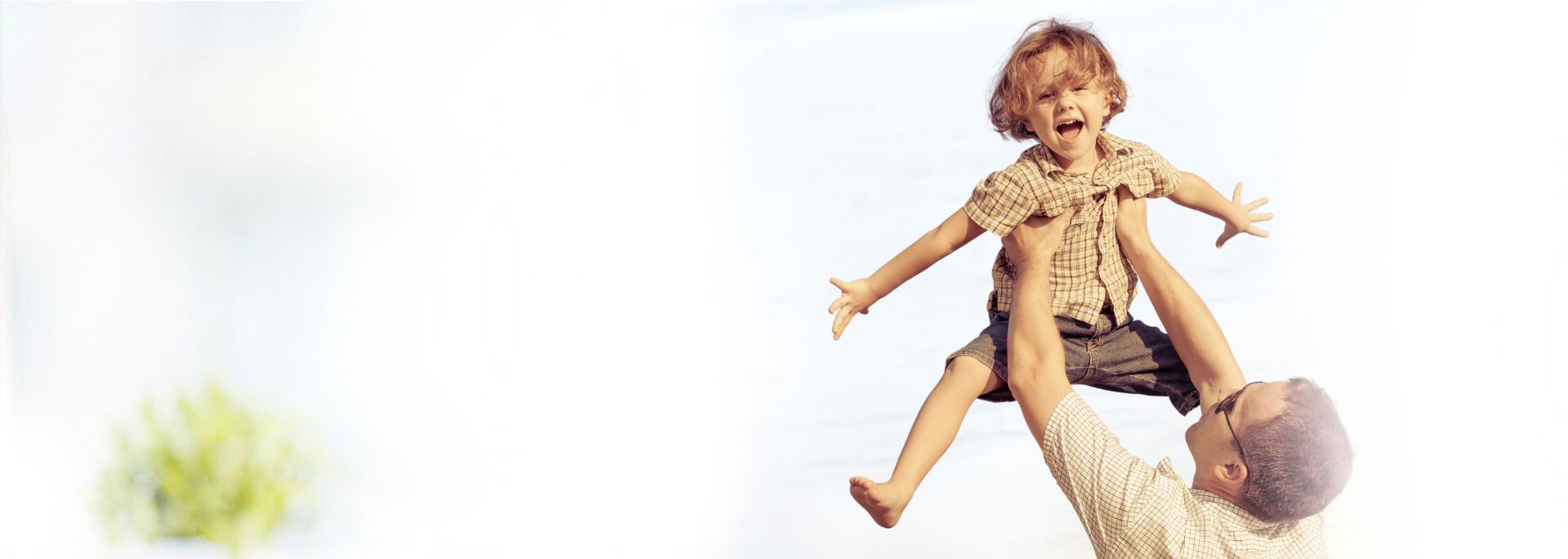 Dad tossing up his young son, happy to be a life insurance client of Odiorne Insurance of Brandon, Florida